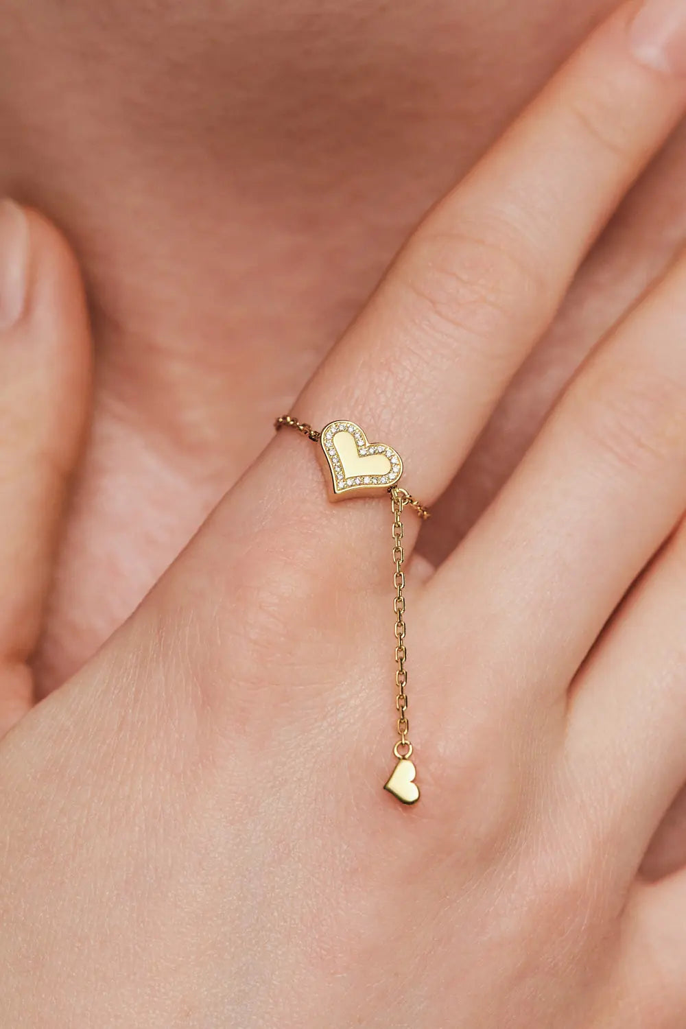 Transforming ring, heart on a chain with diamonds along the contour, yellow gold