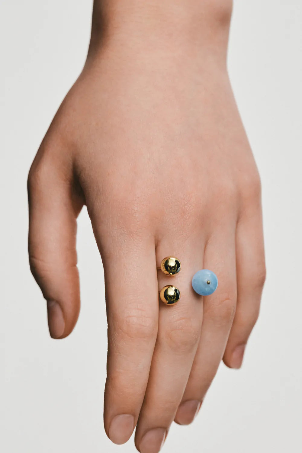 Ring with two gold and one aquamarine spheres, yellow gold